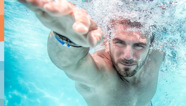 Unterwasseraufnahme von einem Mann beim Kraulschwimmen