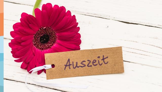 Rote Nelke auf weißem Holztisch mit Anhänger Auszeit